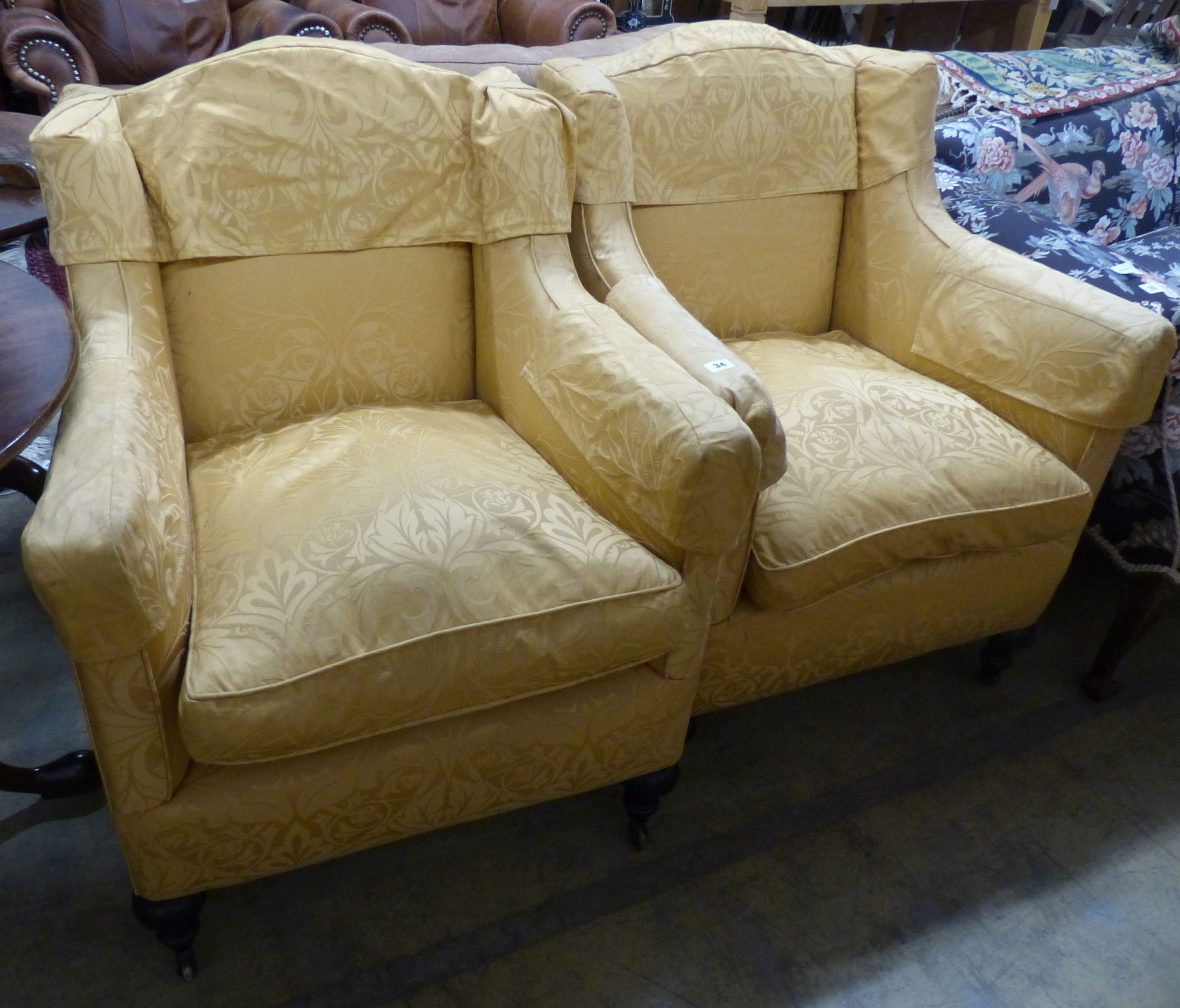 A pair of Victorian square framed armchairs, upholstered in gold damask, on carved legs and castors, W.70cm D.70m H.92cm